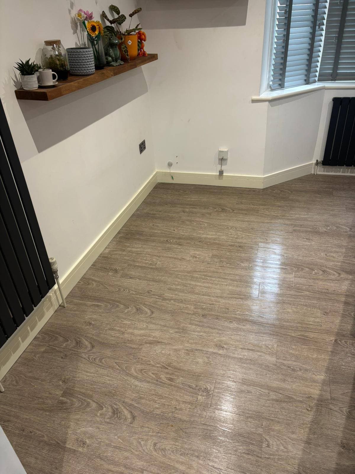The same wood-effect floor swept and mopped clean with the room tidied after cleaning